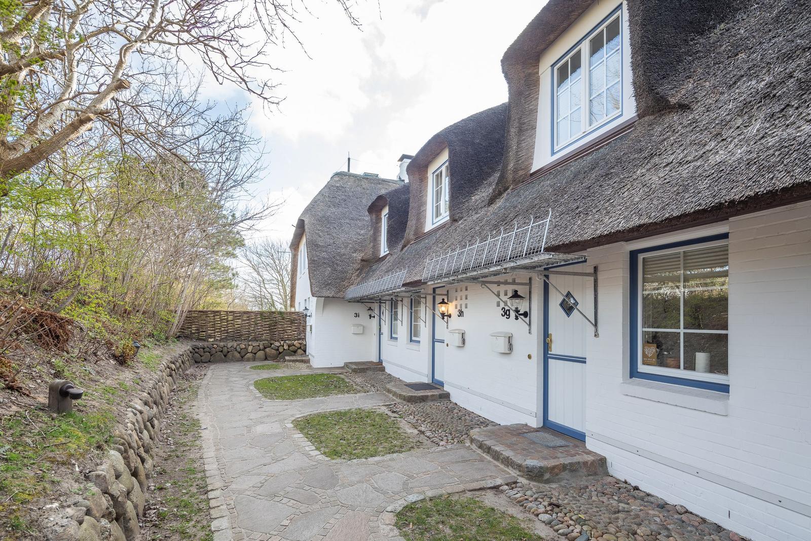 White houses with thatched roofs and stone garden path