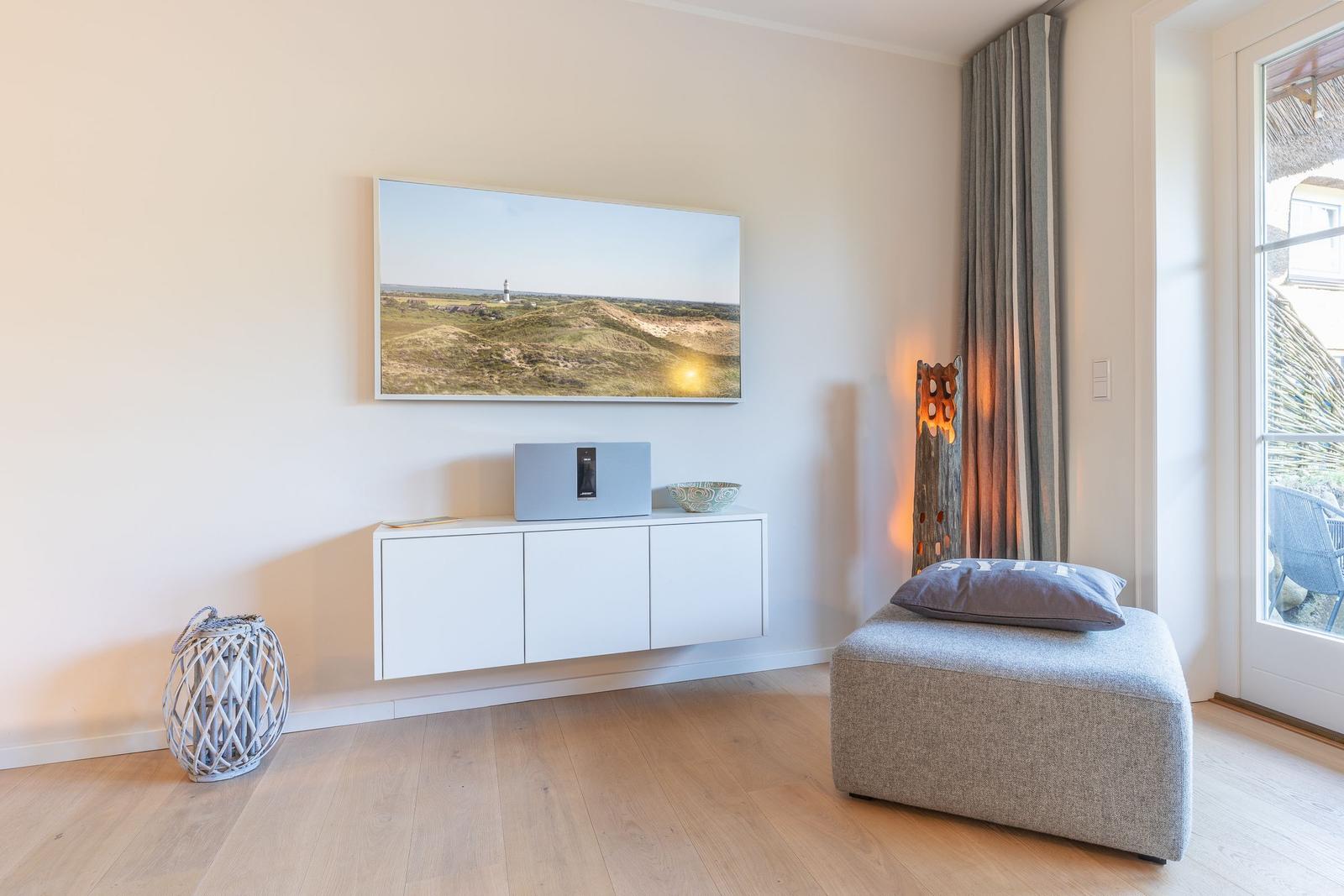 Living room with wall art, cabinet, and ottoman. Access to terrace.