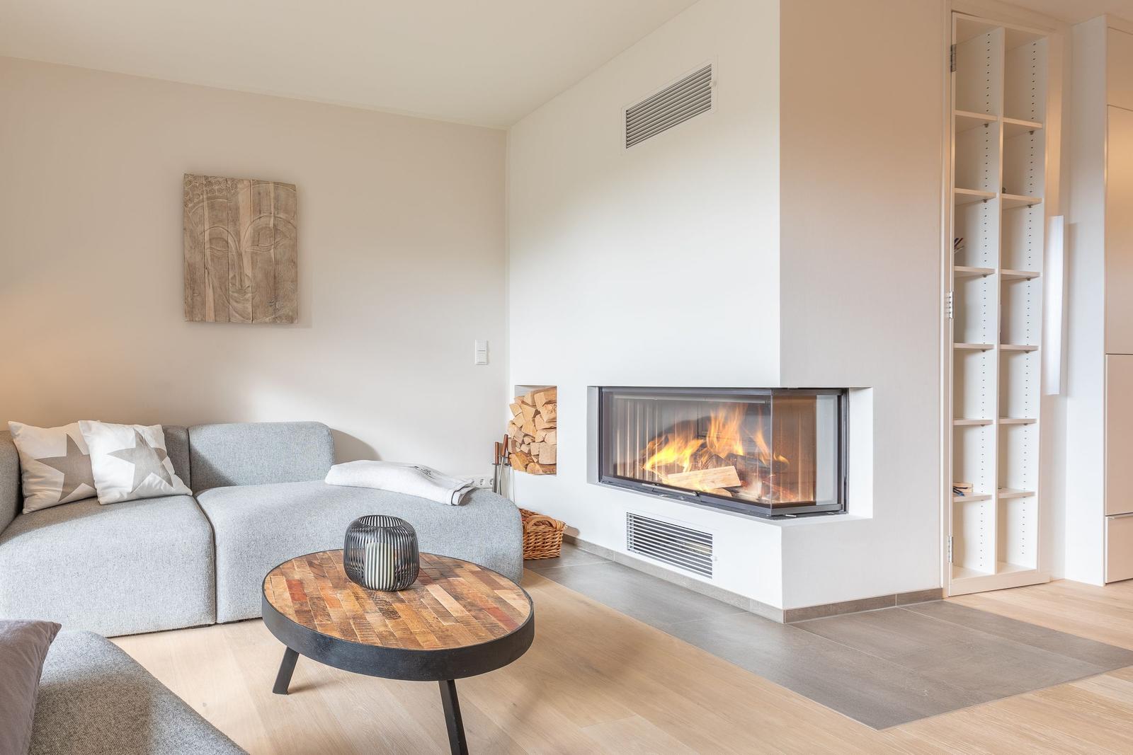 Living room with sofa, fireplace, and wooden table.