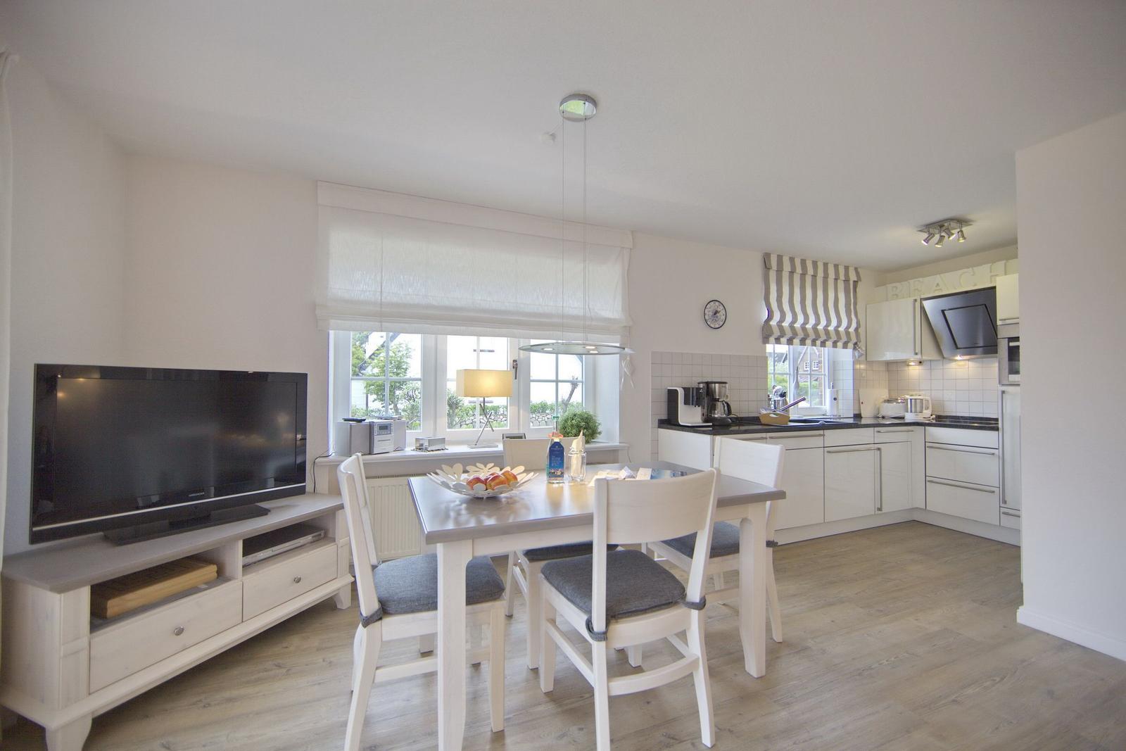 Kitchen and dining area with dining table, chairs, and TV
