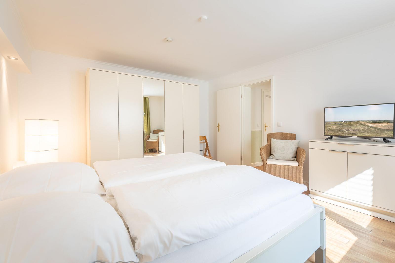 Schlafzimmer mit Doppelbett, Kleiderschrank und Fernseher