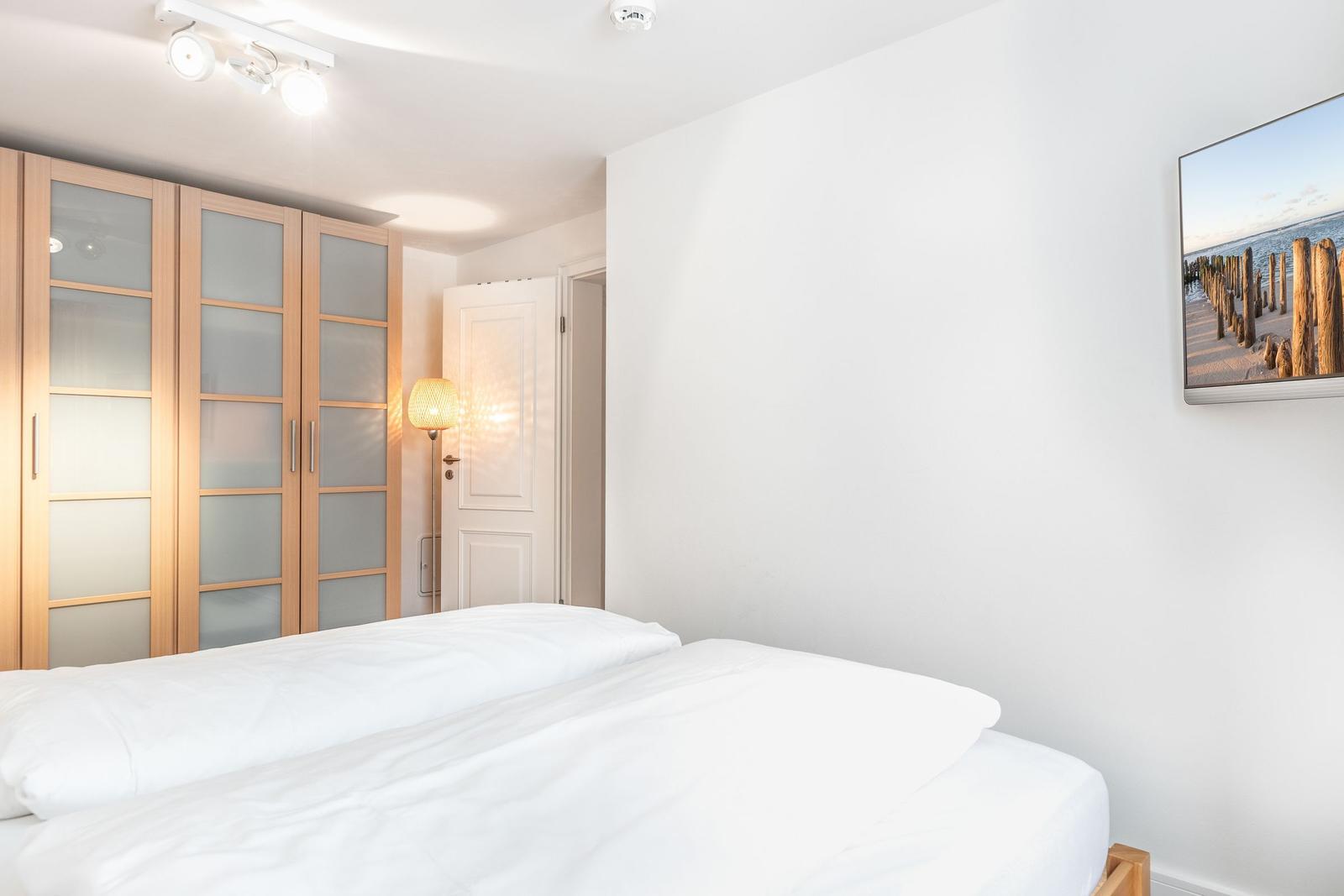 Bedroom with bed, wardrobe, and wall picture