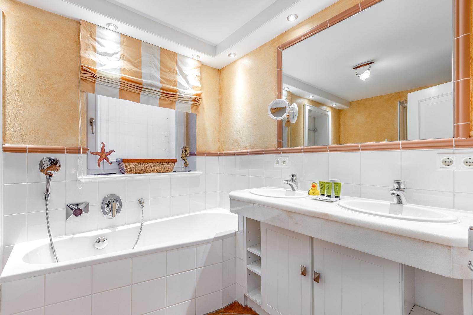 Bath with bathtub, double sink, and mirror
