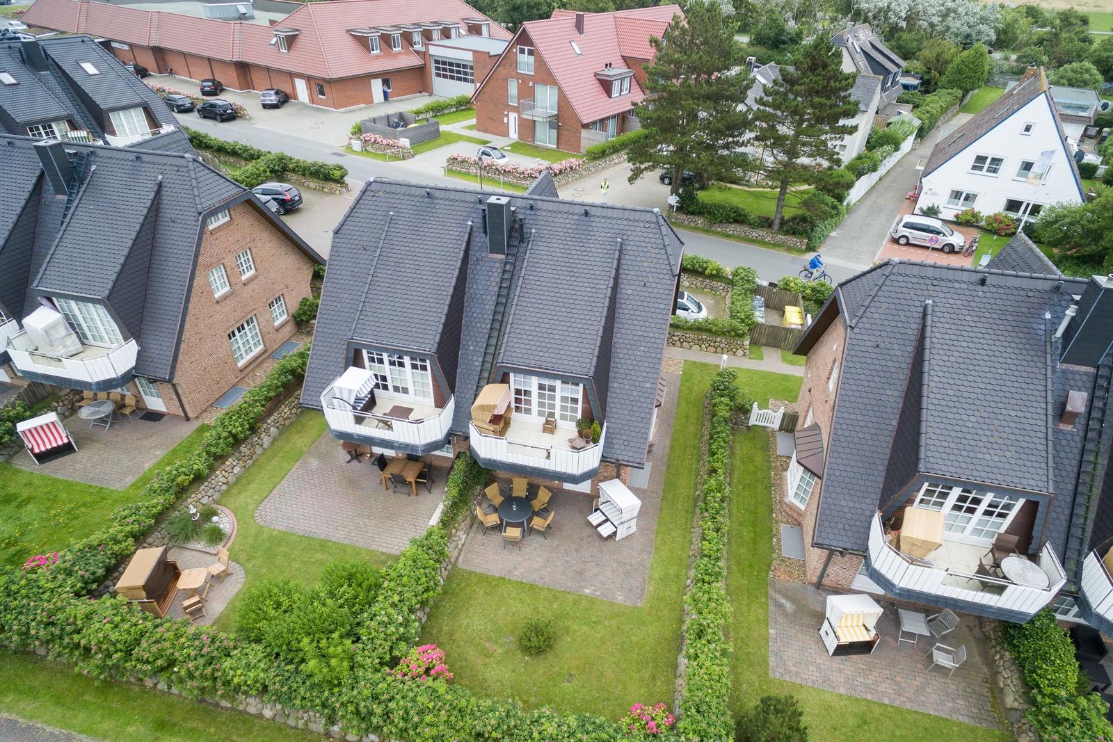 Haus mit Terrasse, Garten und Grillplatz. Umgebung mit weiteren Häusern.