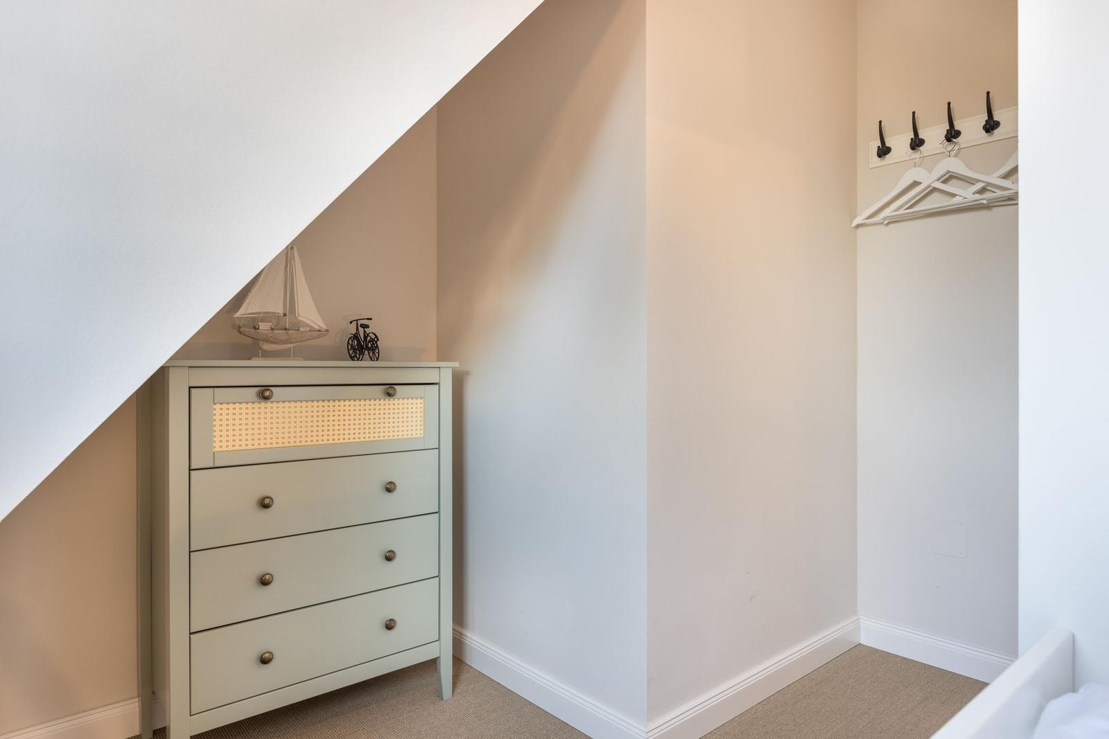 Schlafzimmer mit Kleiderschrank und Wandschrank unter Dachschräge.