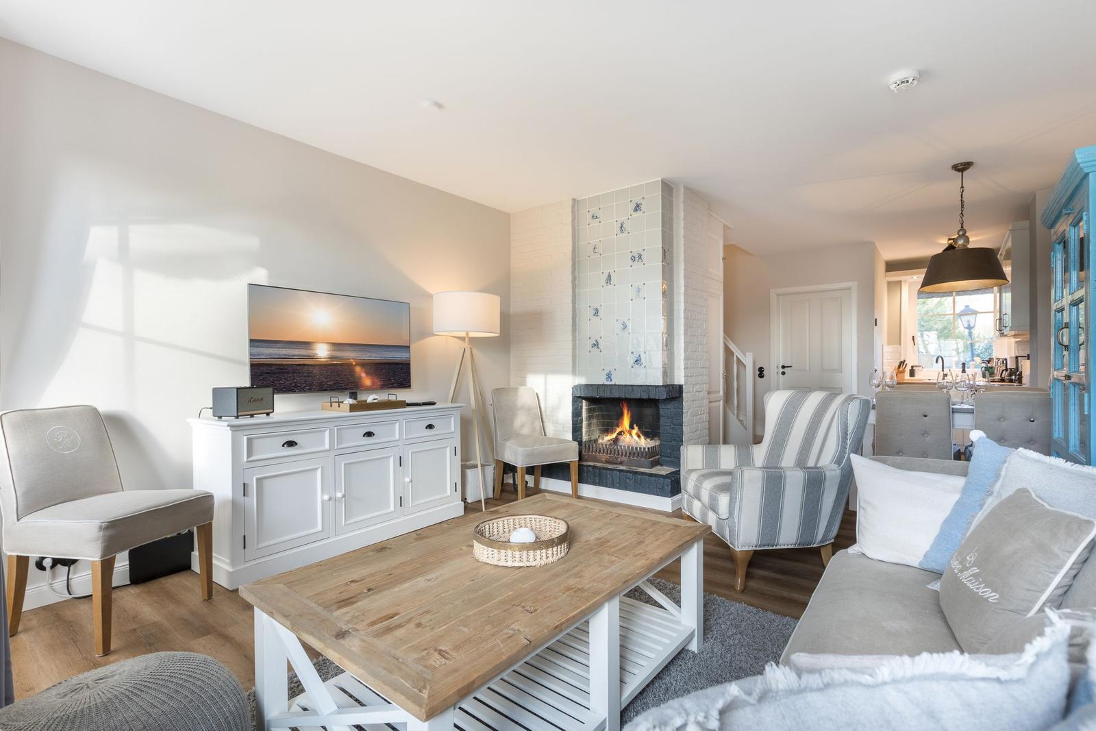 Wohnzimmer mit Kamin, Sofa, Fernseher und Essbereich