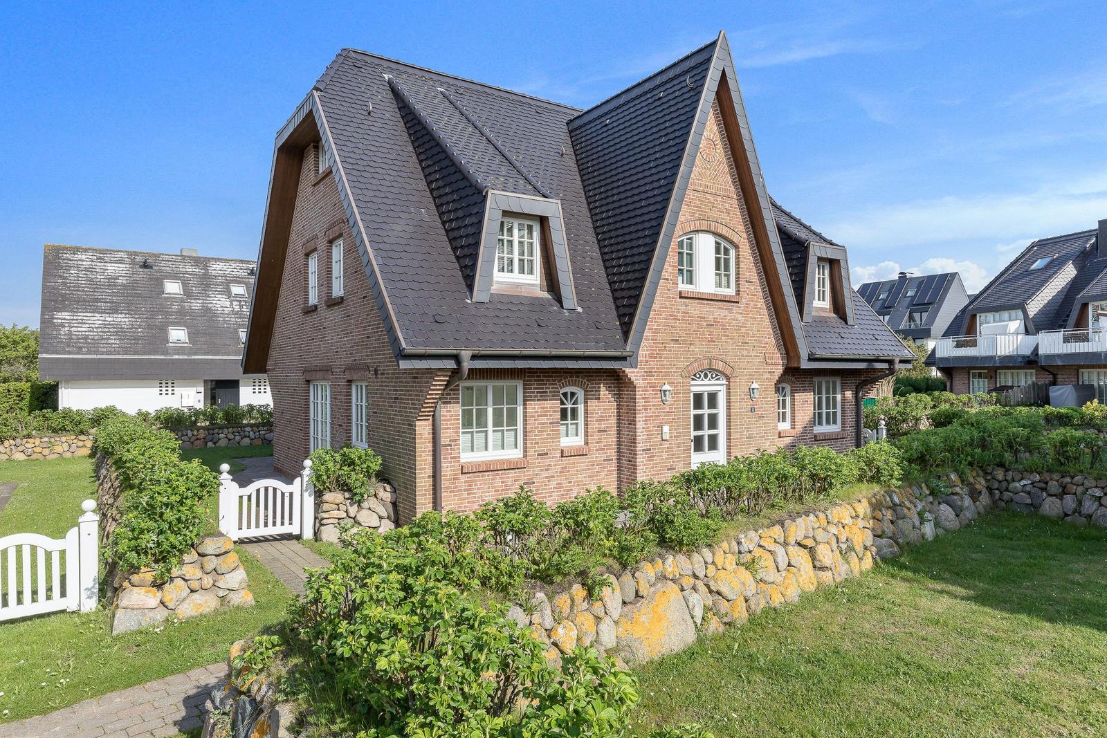Two-story house with stone wall and white windows