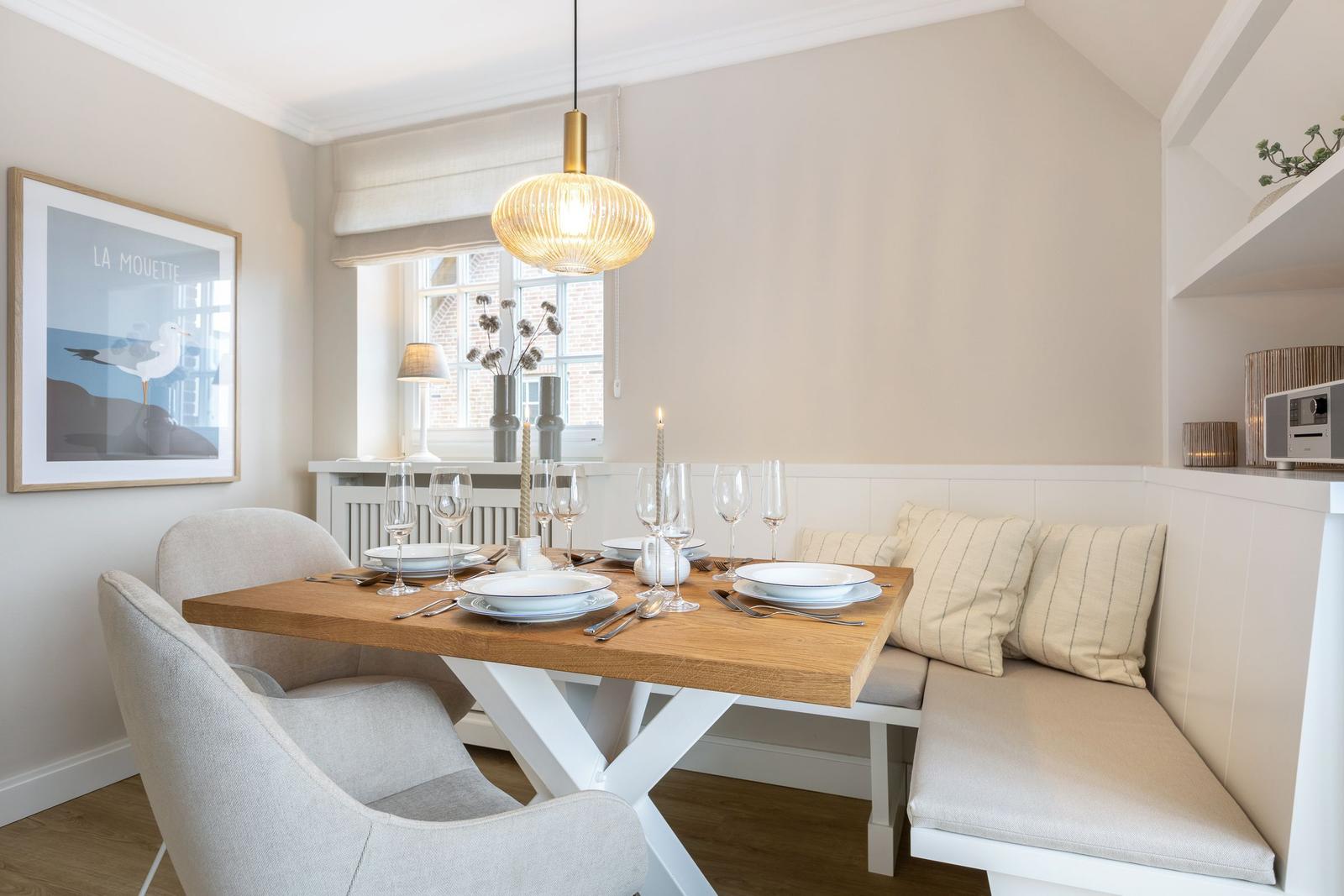 Dining table with bench, window, and ceiling light.