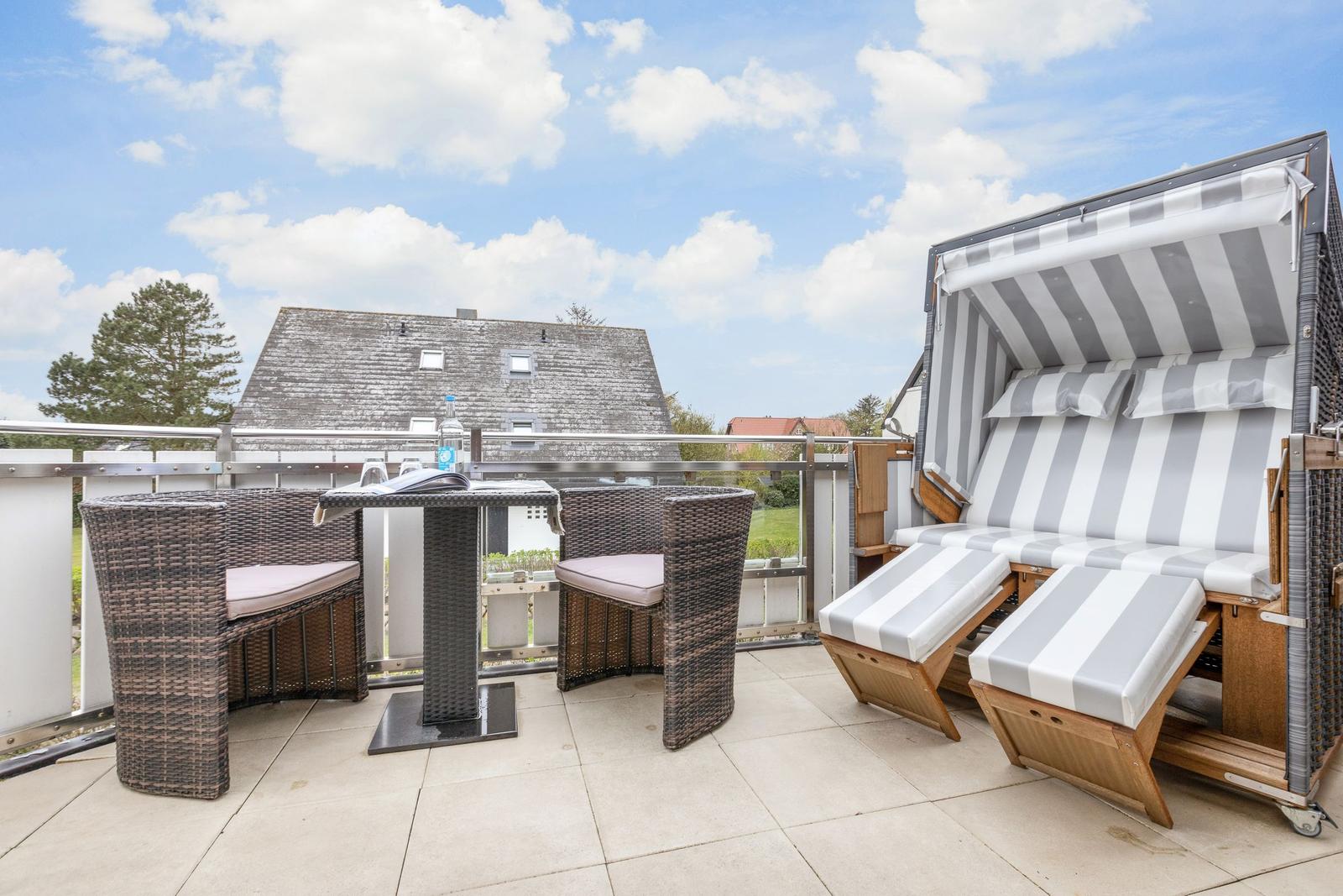 Terrace with seating group and beach chair. Background: house and tree.