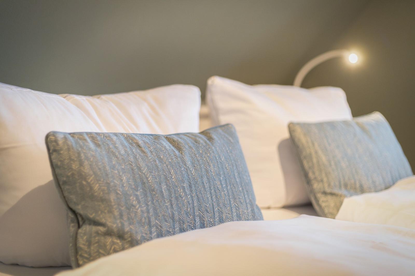 Bed headboard with pillows and reading lamp