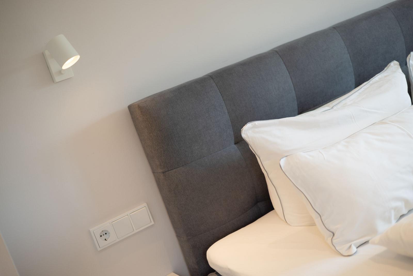Bed headboard with pillows and wall lamp