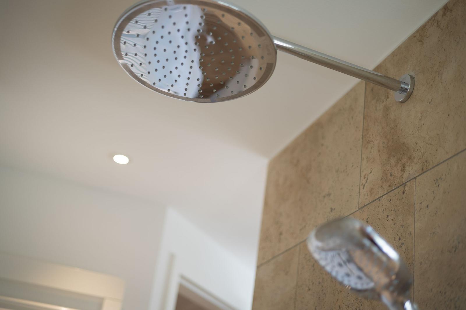 Showerhead on ceiling and handheld shower on wall