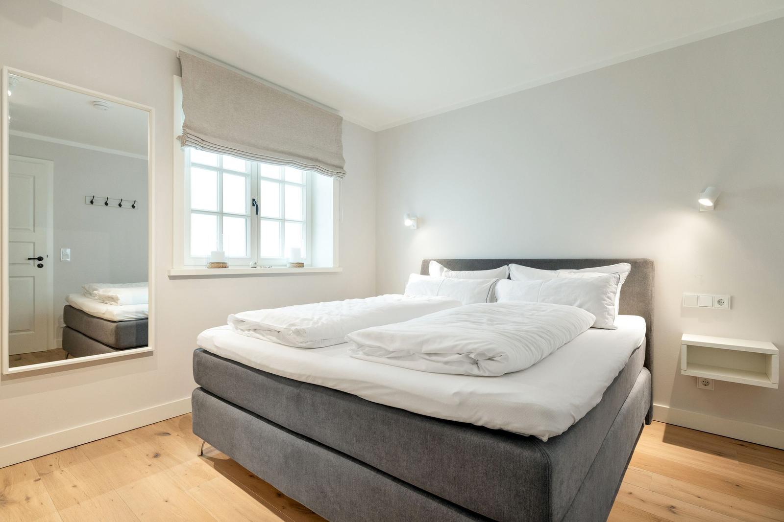 Bedroom with double bed, window, and mirror