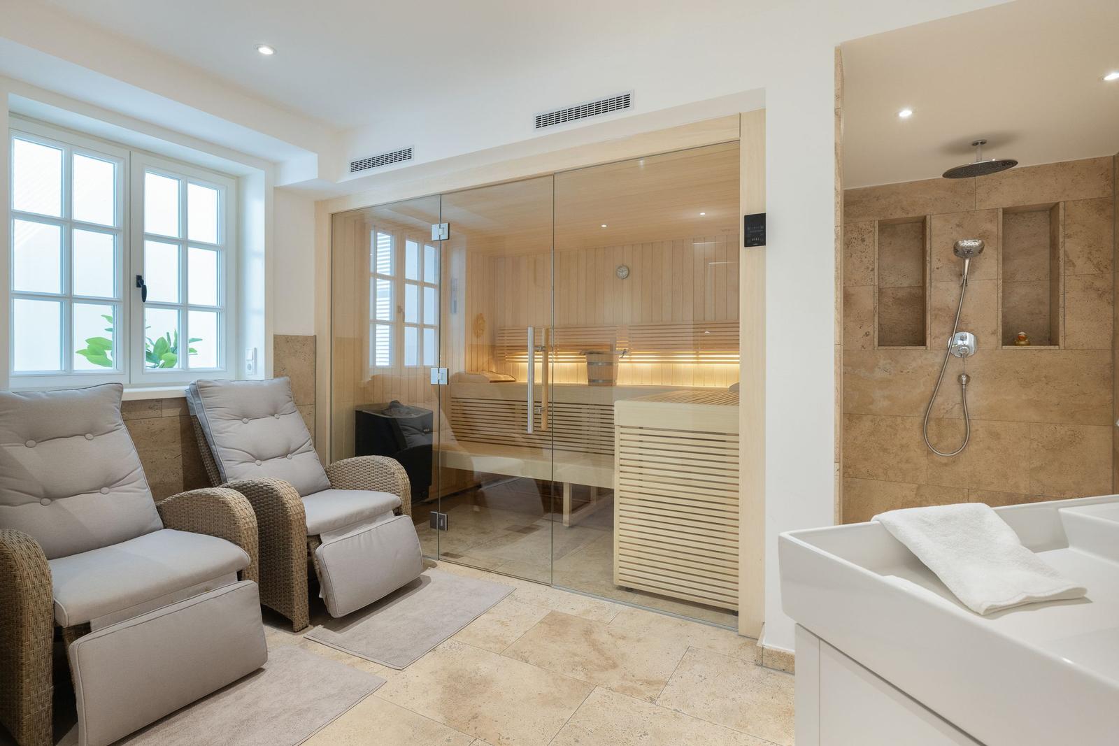 Sauna with glass wall, shower, and hot tub in one room.