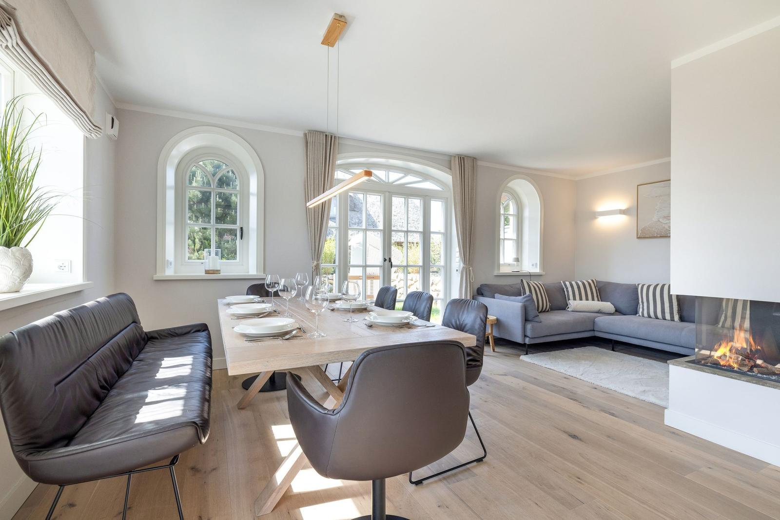 Dining area with table and chairs, living area with sofa and fireplace