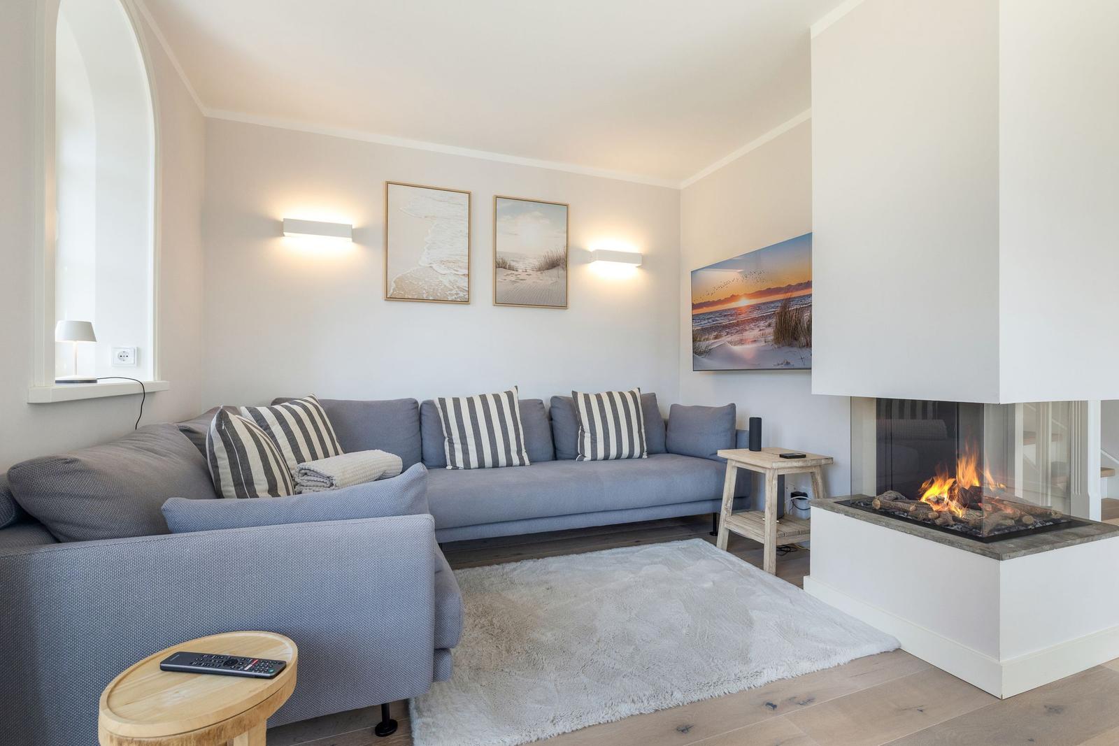 A living room with gray sofa, fireplace, and wall art.