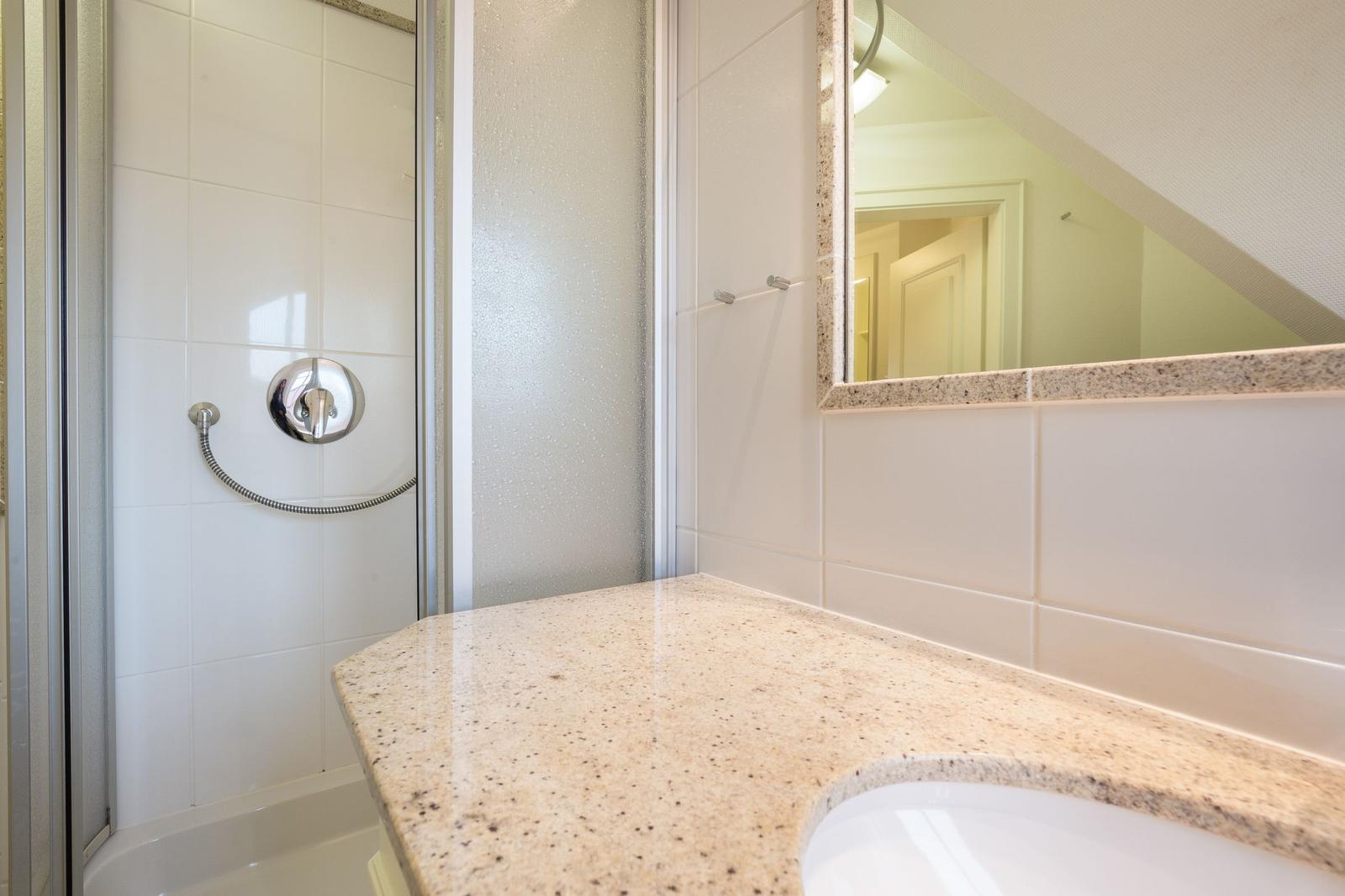 Bathroom with shower, sink, and mirror