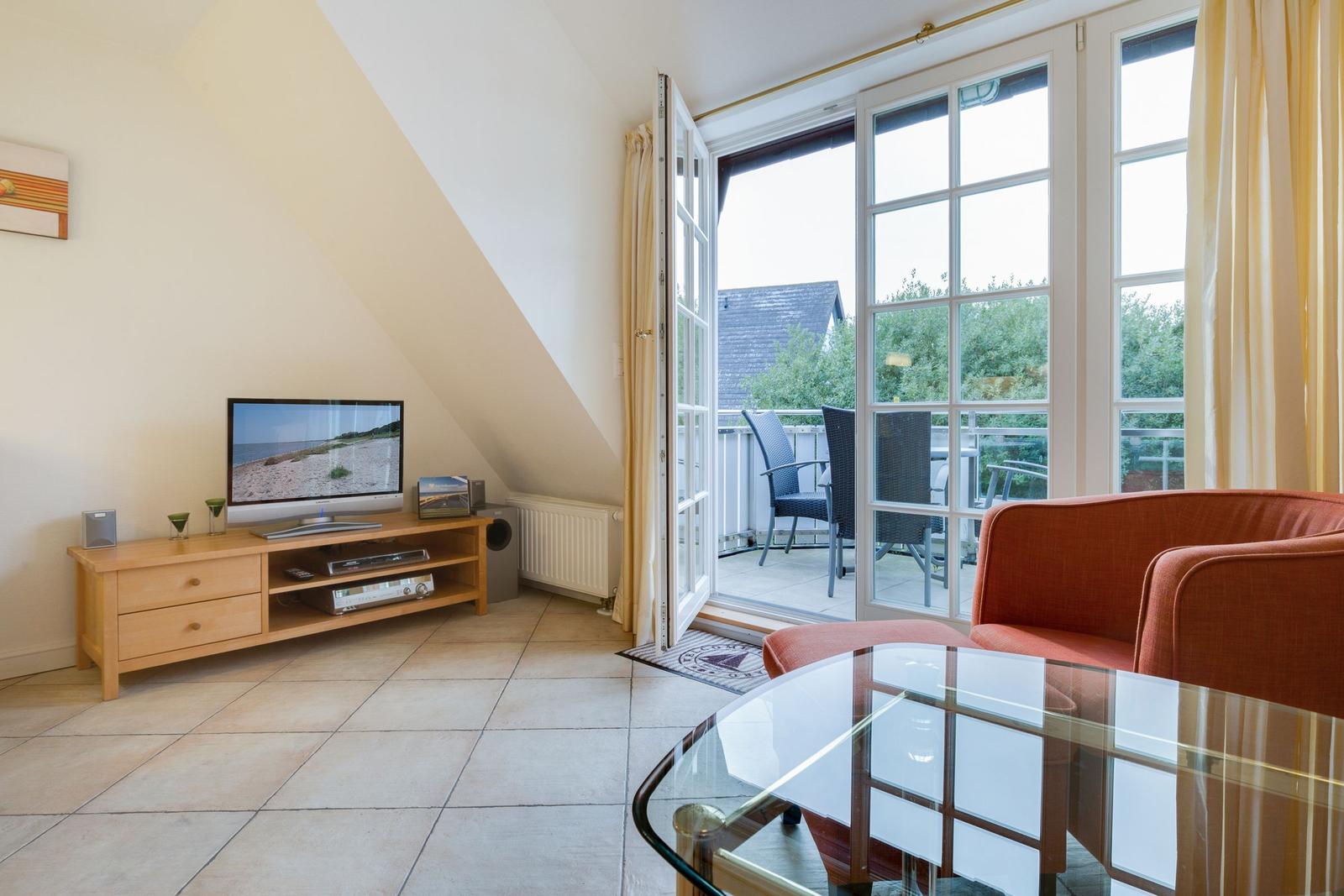 Living room with TV, sofa, and balcony access