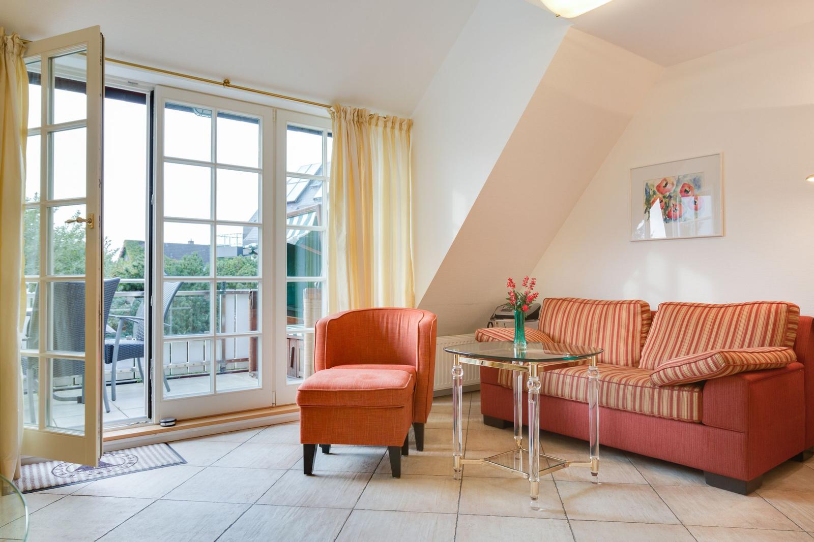 Living room with sofa, armchair, and terrace door