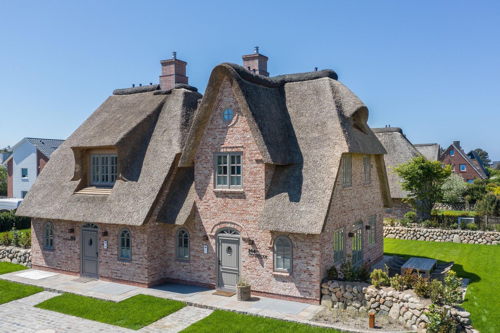 House with thatched roof and brick facade