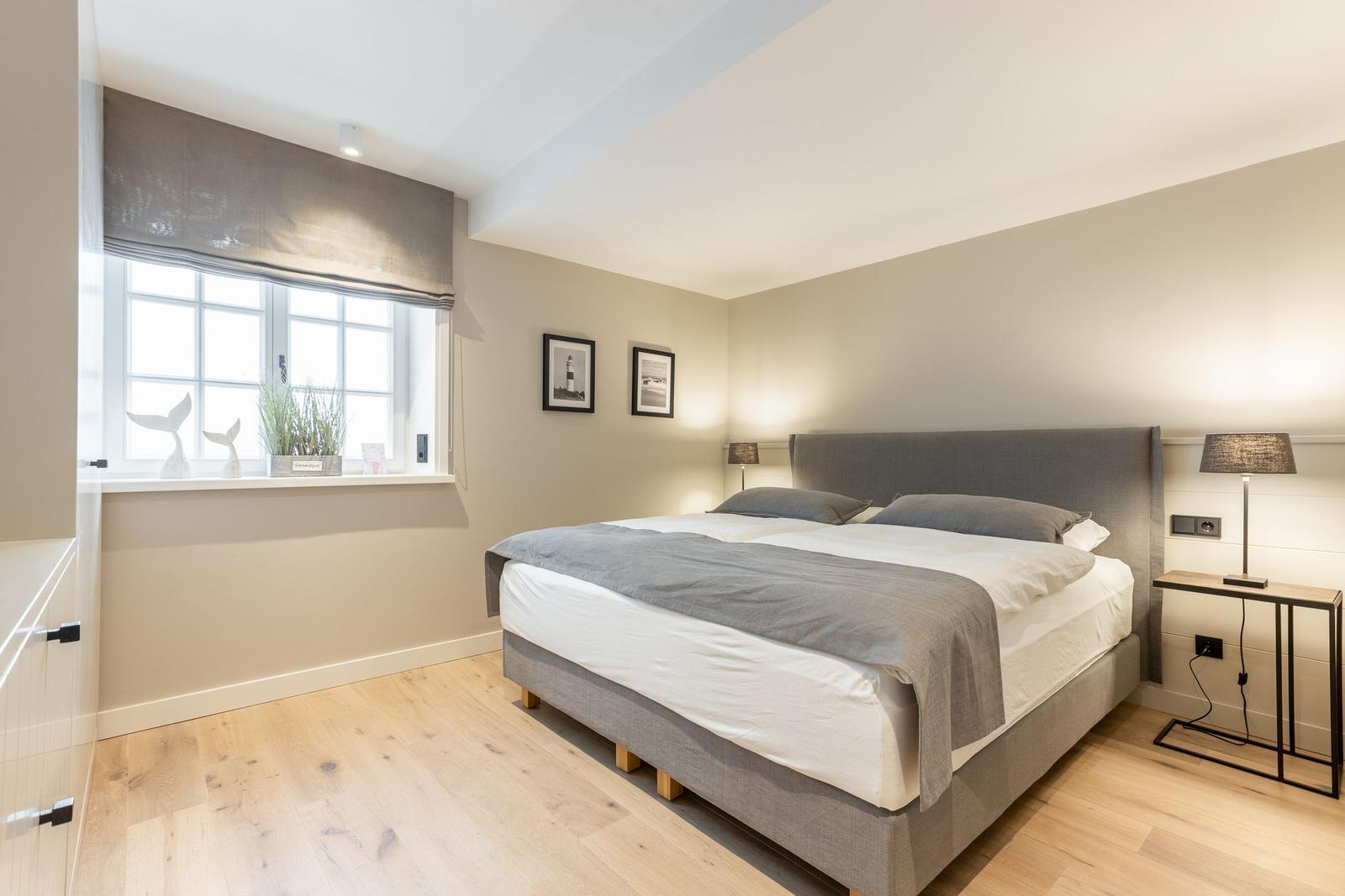 Bedroom with double bed, window, and bedside table