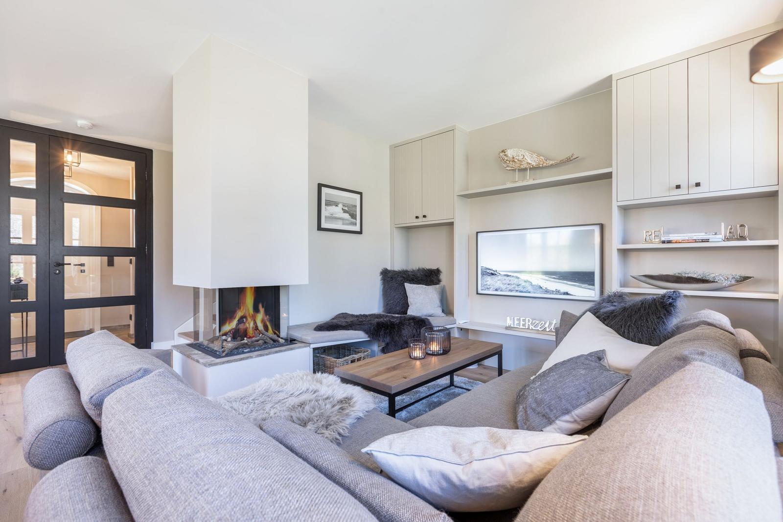 Living room with fireplace, sofa, and TV mounted on the wall.
