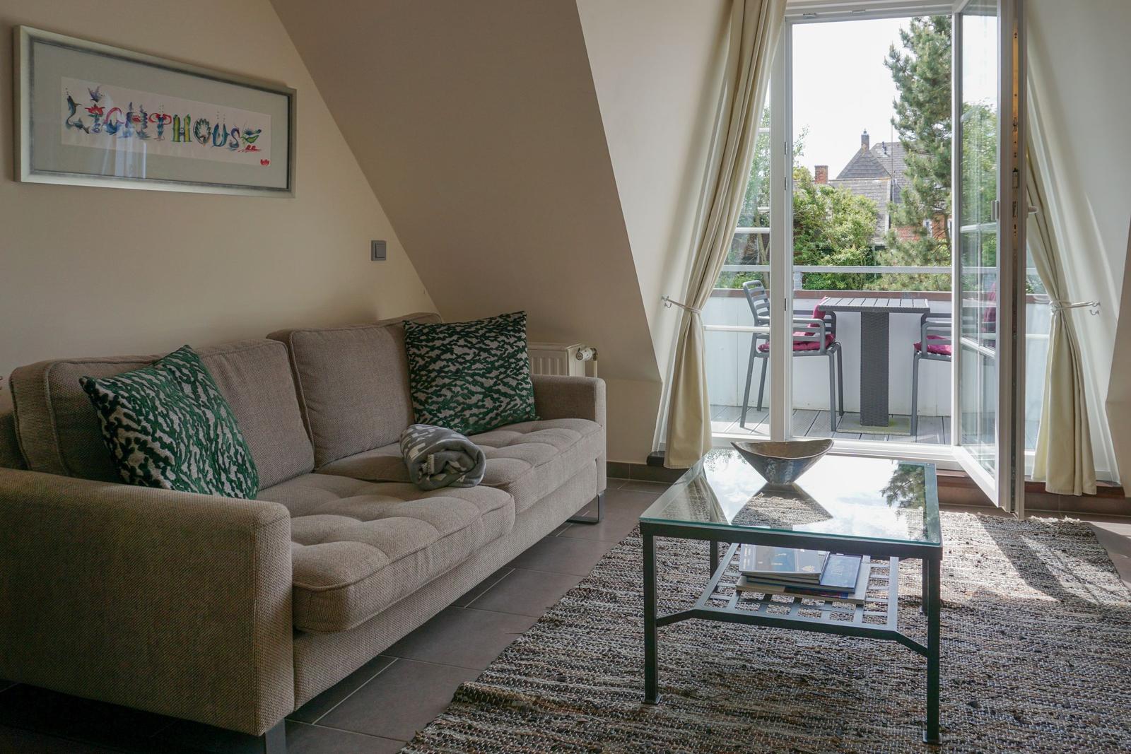 Living room with sofa, coffee table, and balcony view.