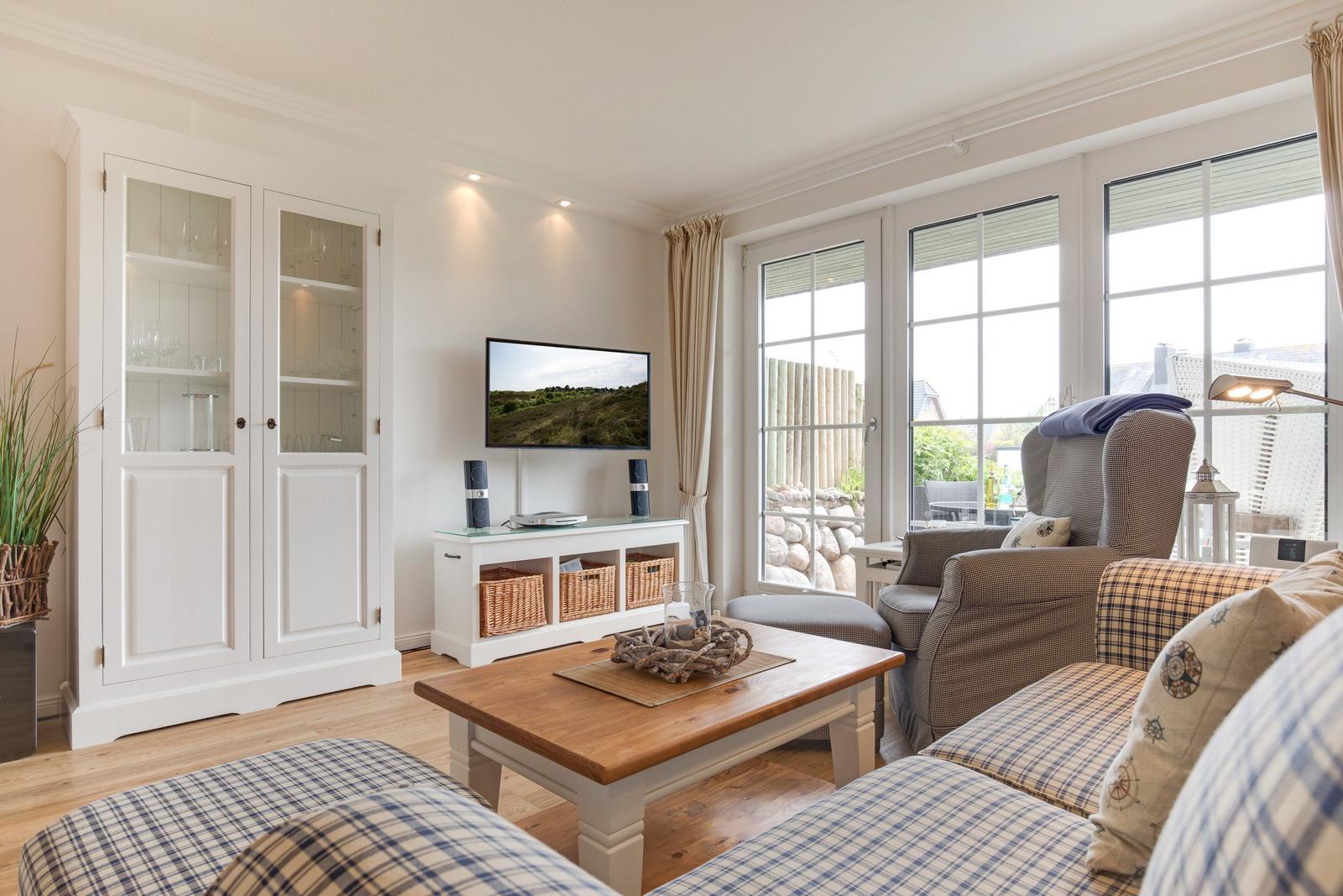 Living room with TV, sofa, and view of the garden.