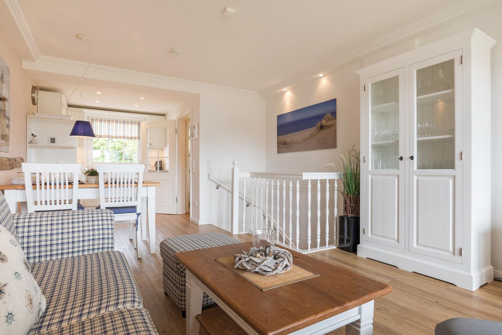 Living and dining area with wooden floor, white sofa, and dining furniture.