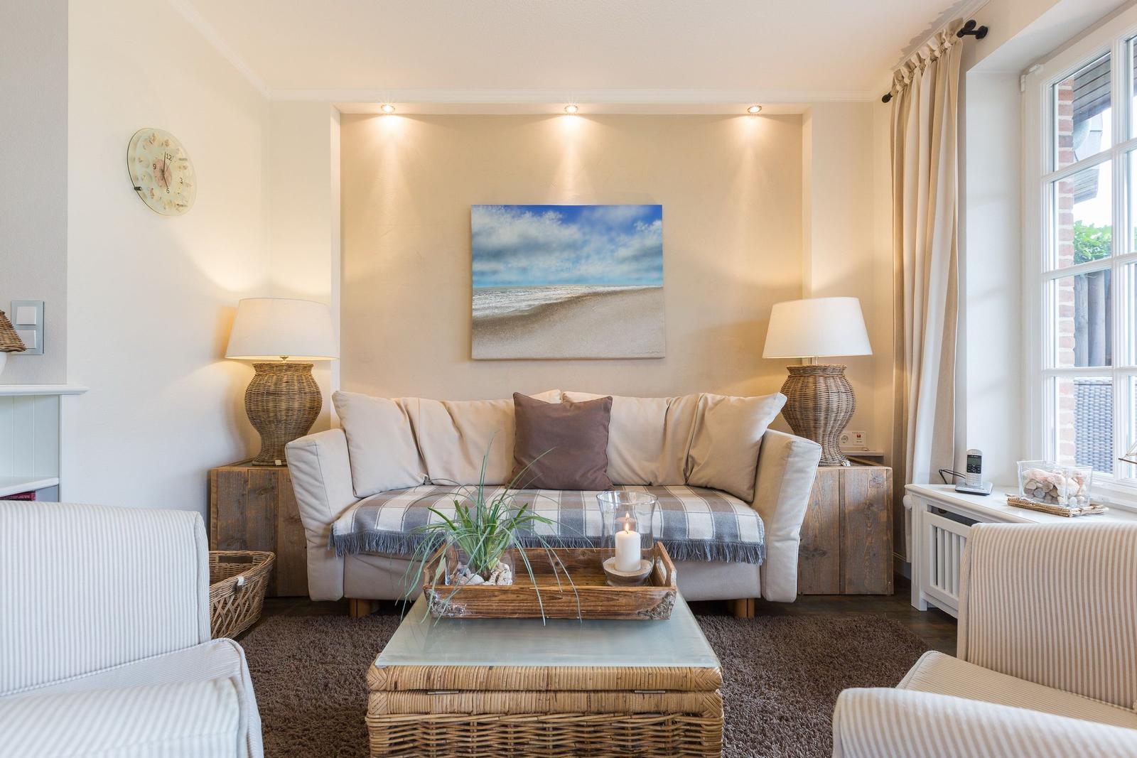 Wohnzimmer mit Sofa, Tisch und Wandbild. Fenster mit Vorhängen.
