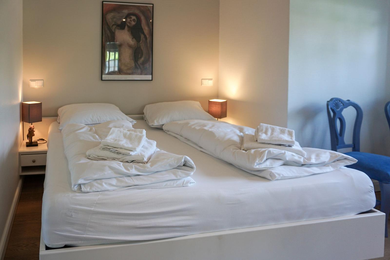 Bedroom with double bed, two nightstands, and wall decoration.