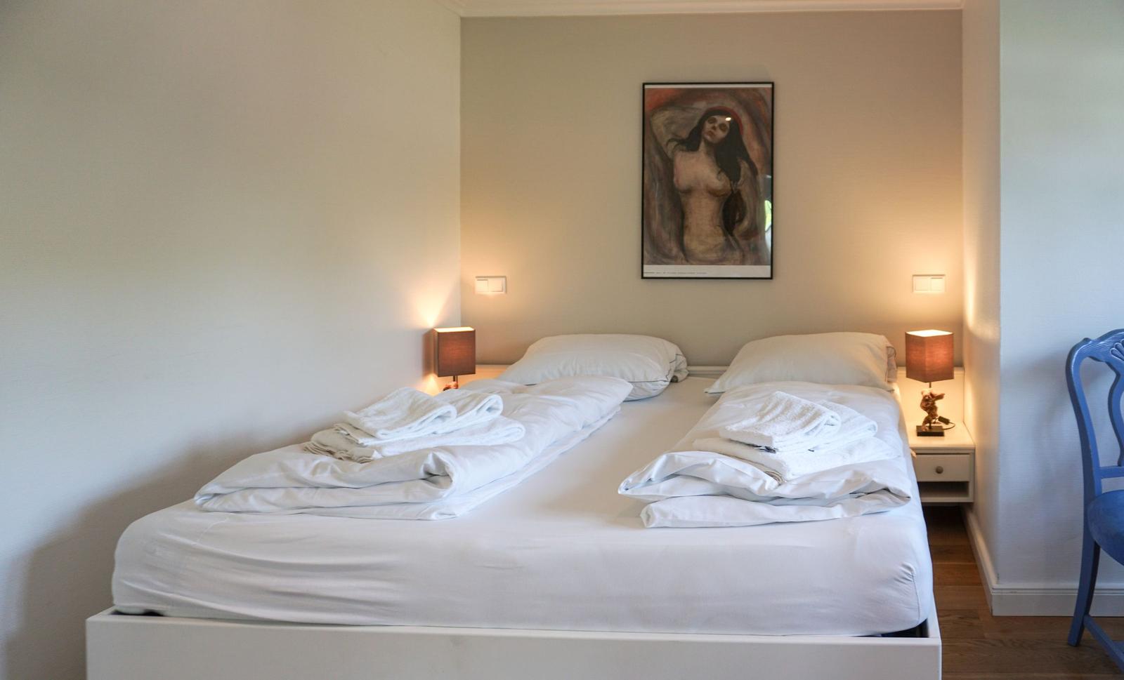Bedroom with bed, nightstands, and wall art