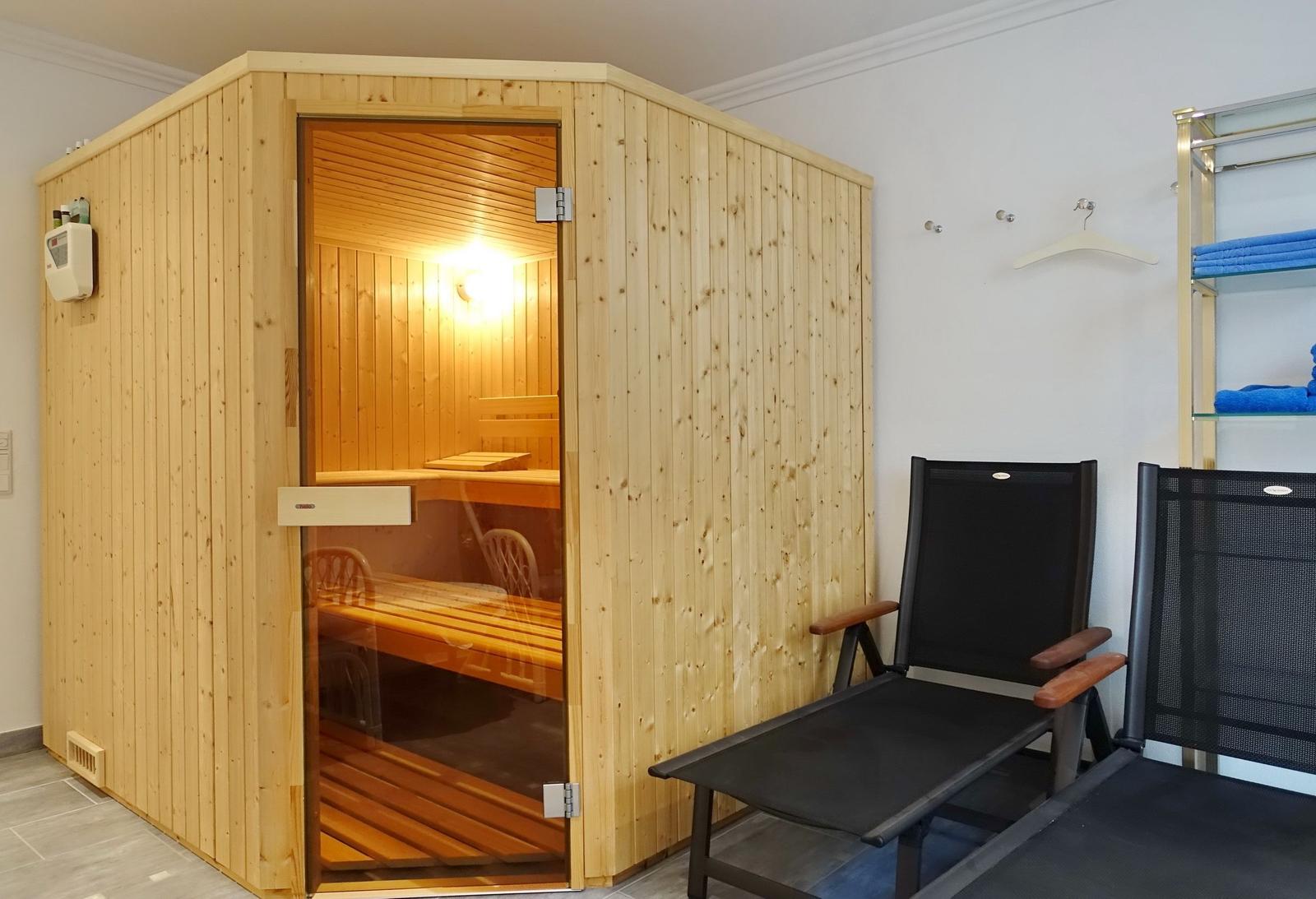 Sauna with wooden cladding and two chairs outside