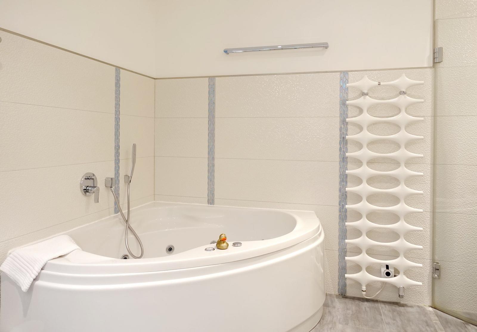 Shower with whirlpool bathtub, handheld shower, and modern heater.