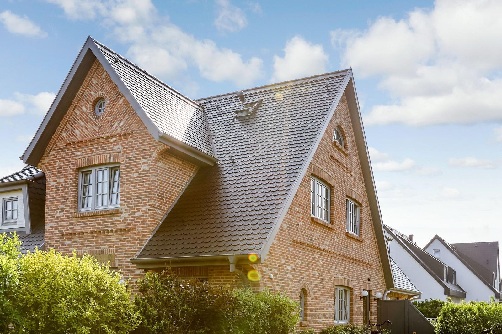 A two-story brick house with sloped roofs and windows.