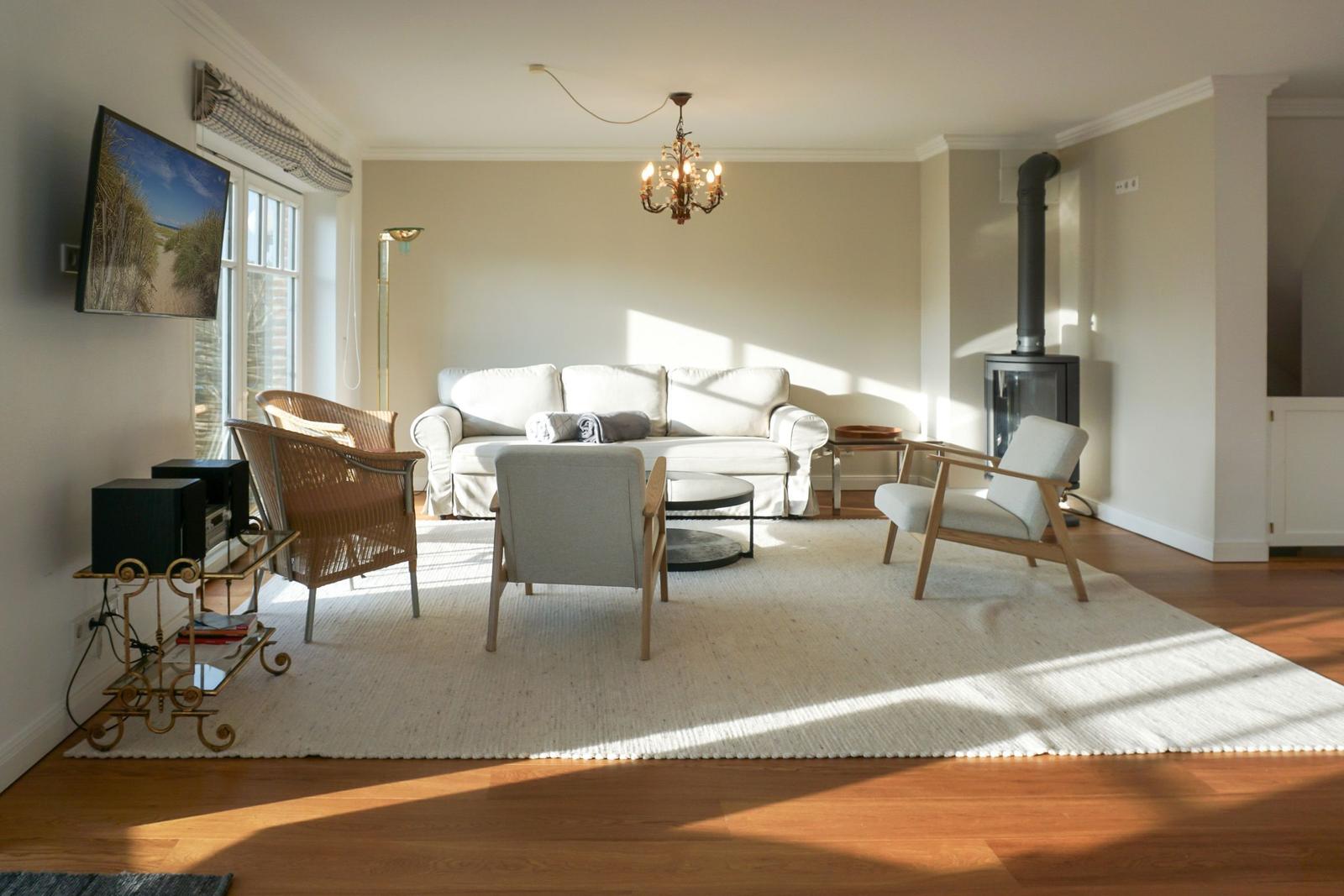 Living room with sofa, chairs, TV, and wood stove.