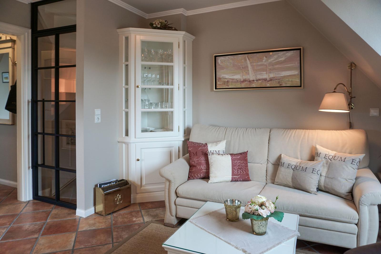 Living room with sofa, coffee table, and wine cabinet under sloped ceiling.