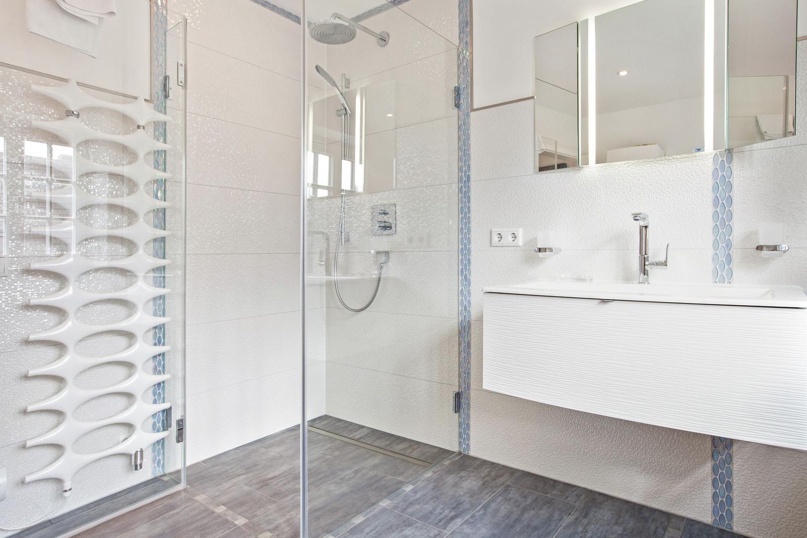 Modern shower with glass enclosure and sink with mirror