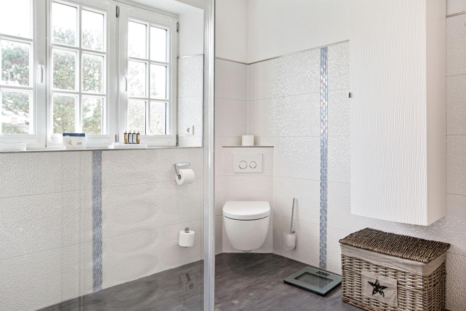 Bathroom with toilet, window, and storage box.