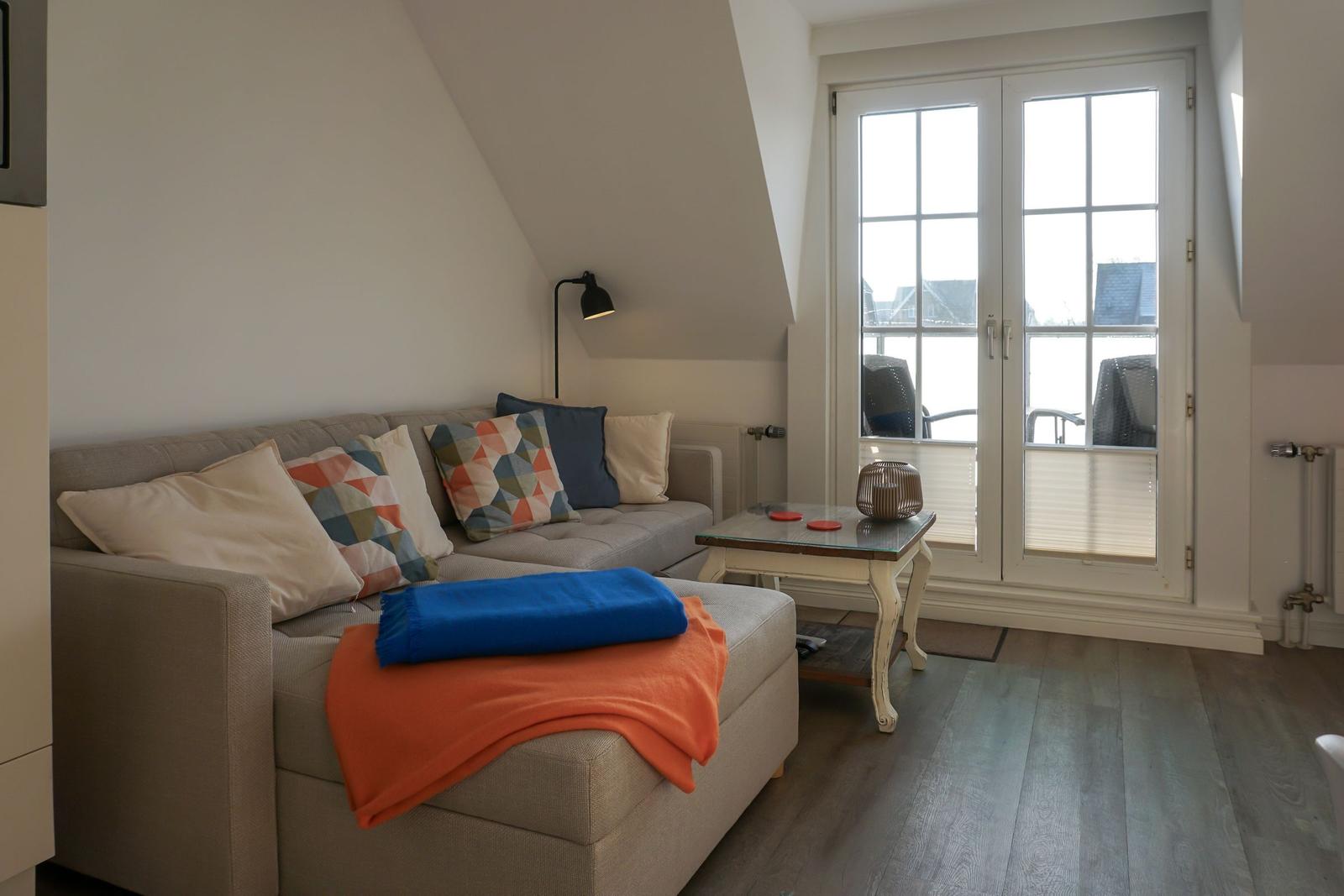 Living room with sofa, table, and window to terrace.