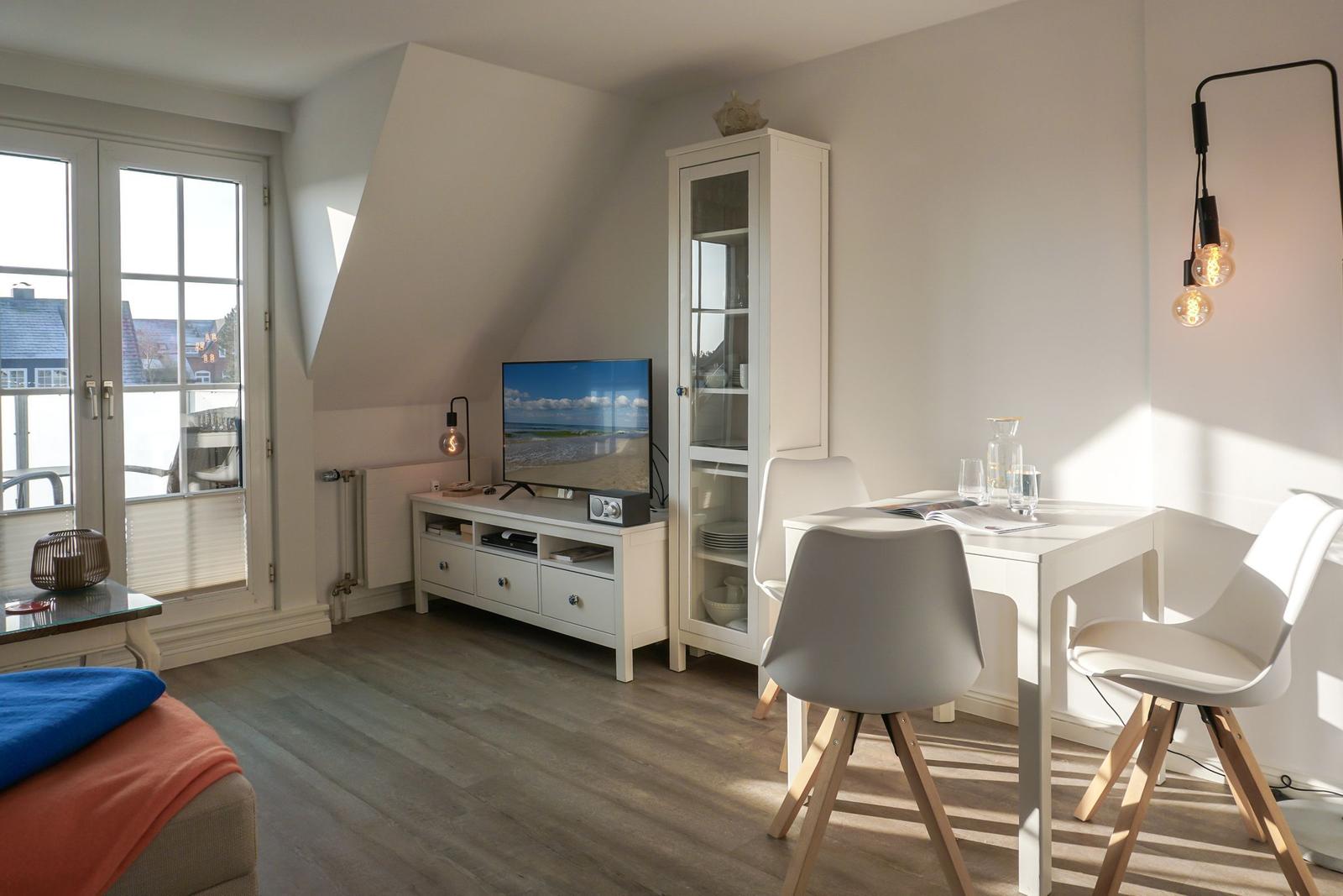 Living area with dining table, TV, and window with view