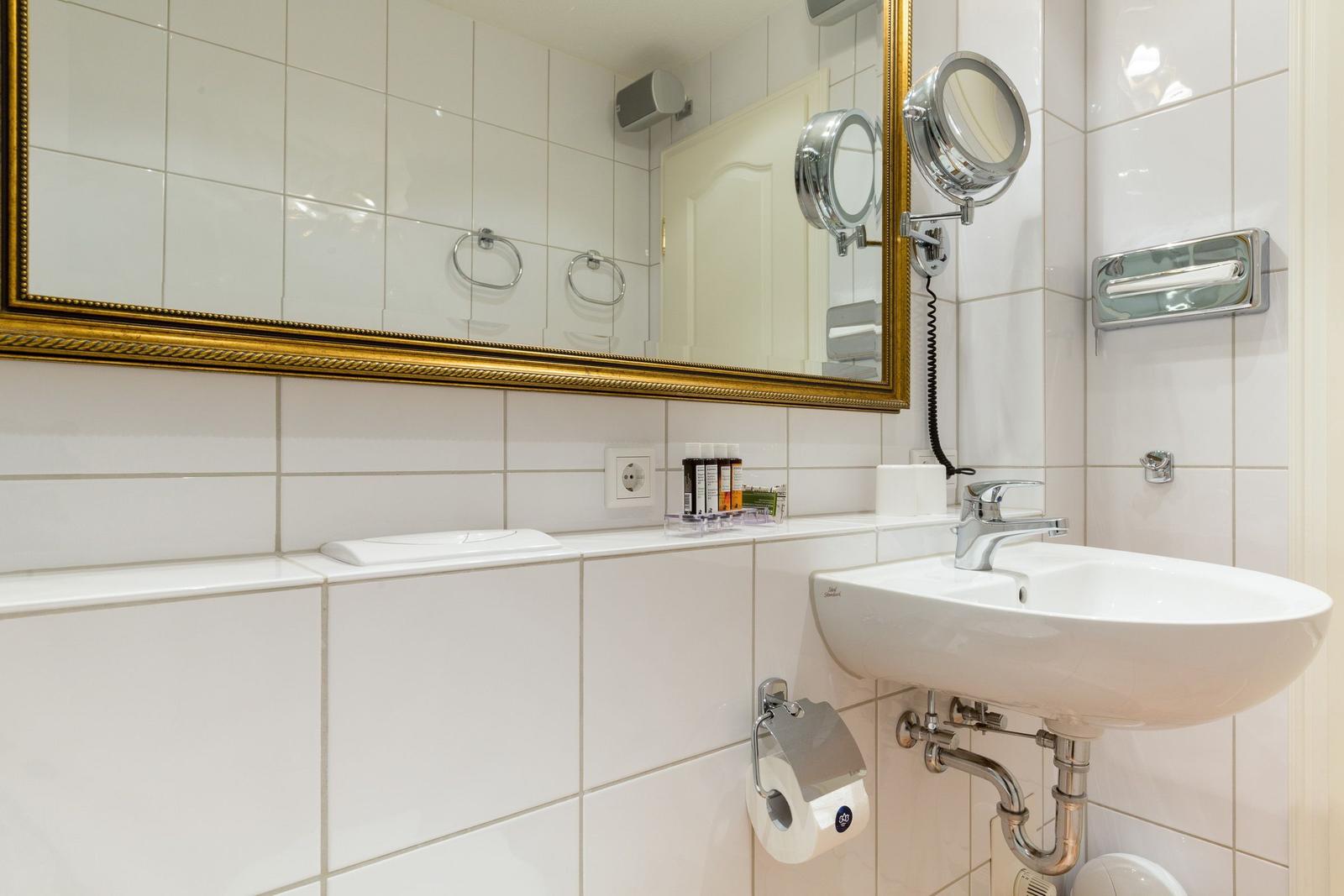 Badezimmer mit Waschbecken, Spiegel und Duschvorhang