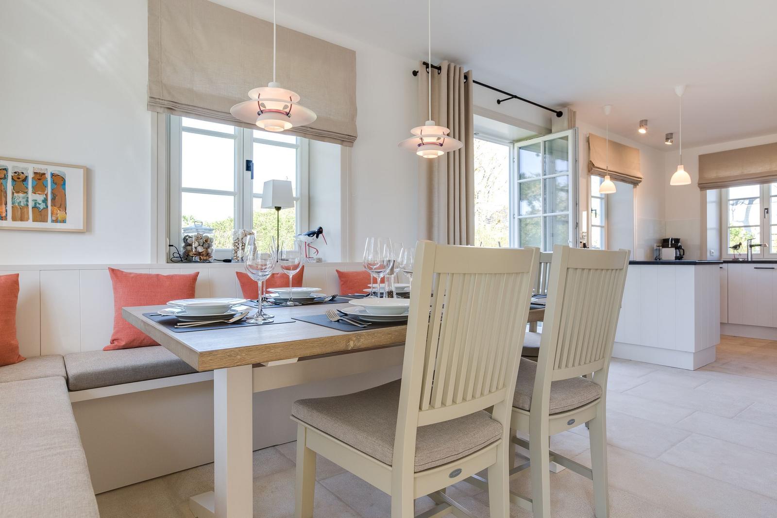Esszimmer mit Tisch, Stühlen und Fensterblick