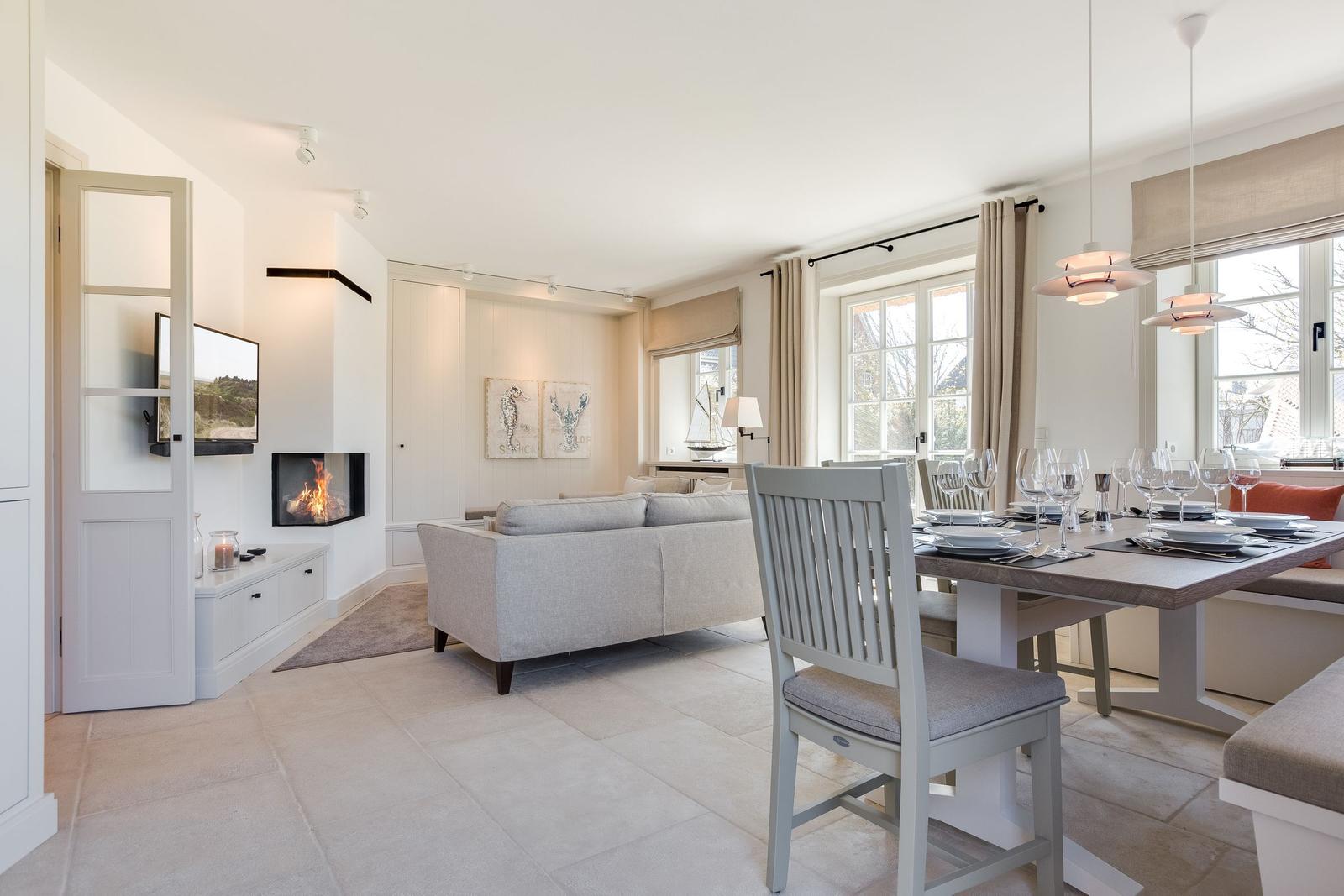 Wohn- und Essbereich mit Sofa, Esstisch und Kamin