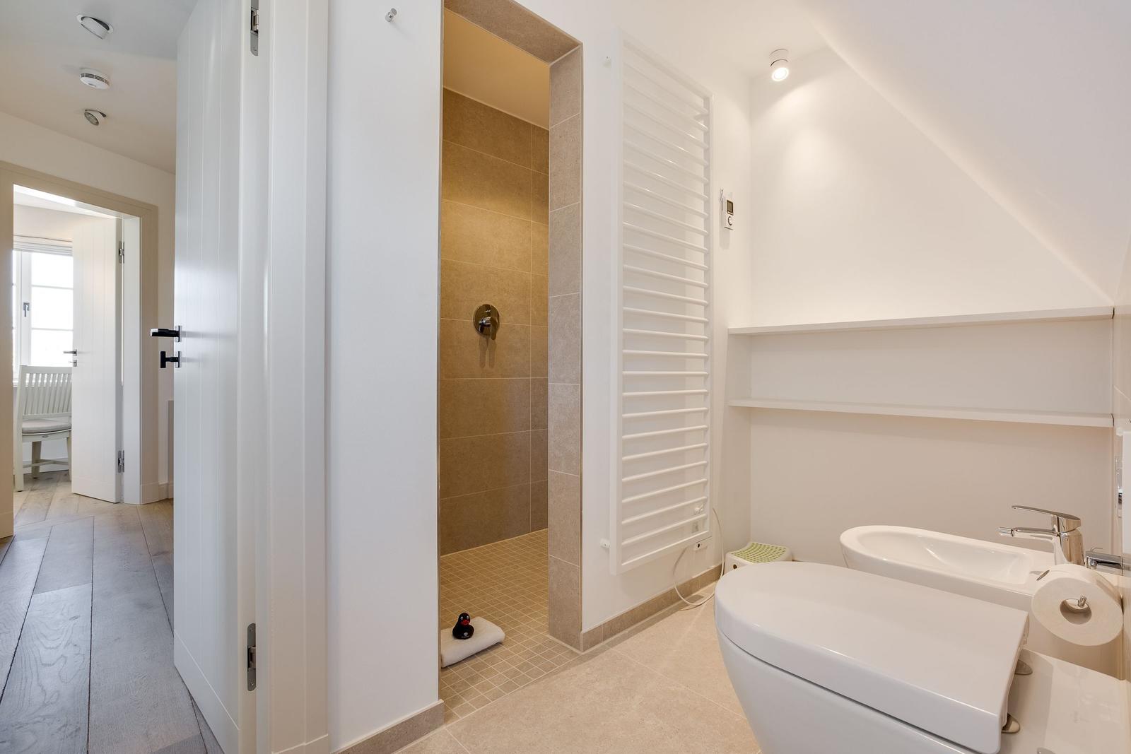 Badezimmer mit Dusche, Toilette und Waschbecken