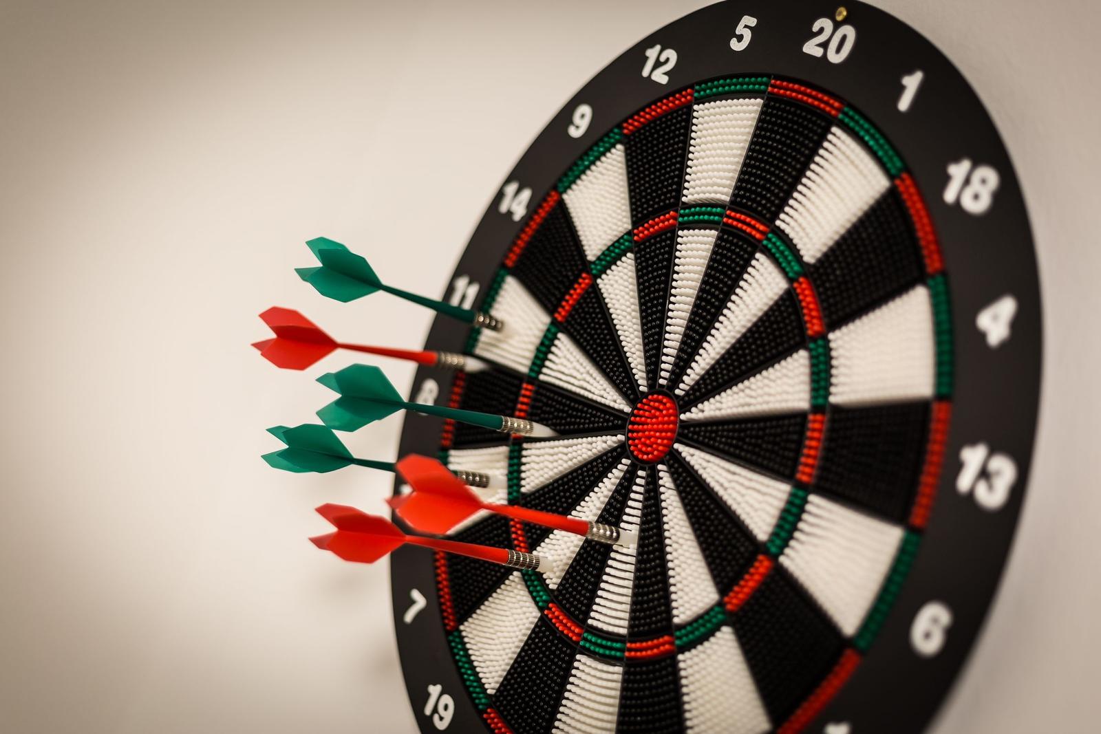 Dartboard mit vier Pfeilen an der Wand
