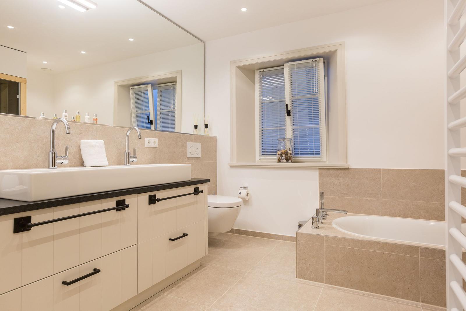 Badezimmer mit Badewanne, Waschbecken und Toilette.