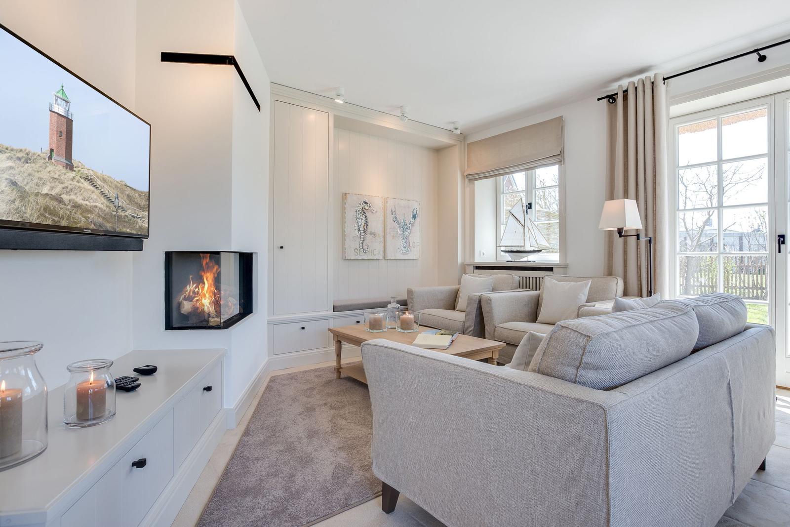 Wohnzimmer mit Sofa, Kamin und Fernseher an der Wand.