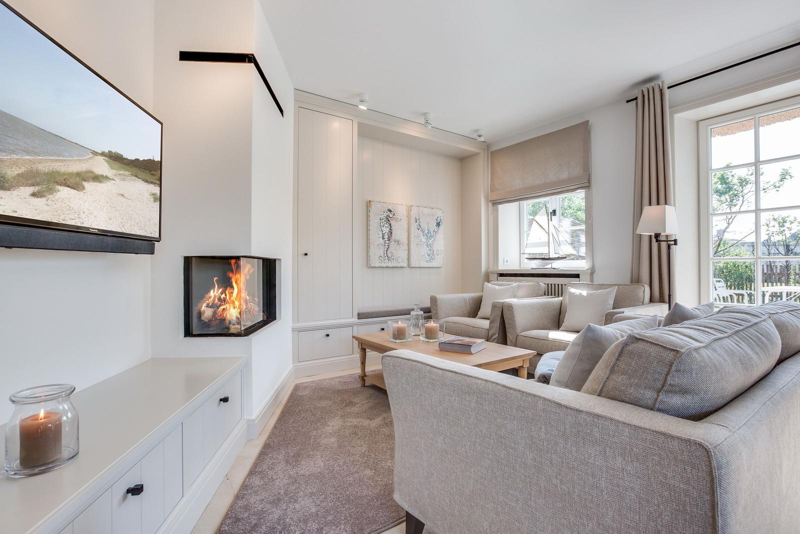 Wohnzimmer mit Kamin, Sofa und Fernseher an der Wand
