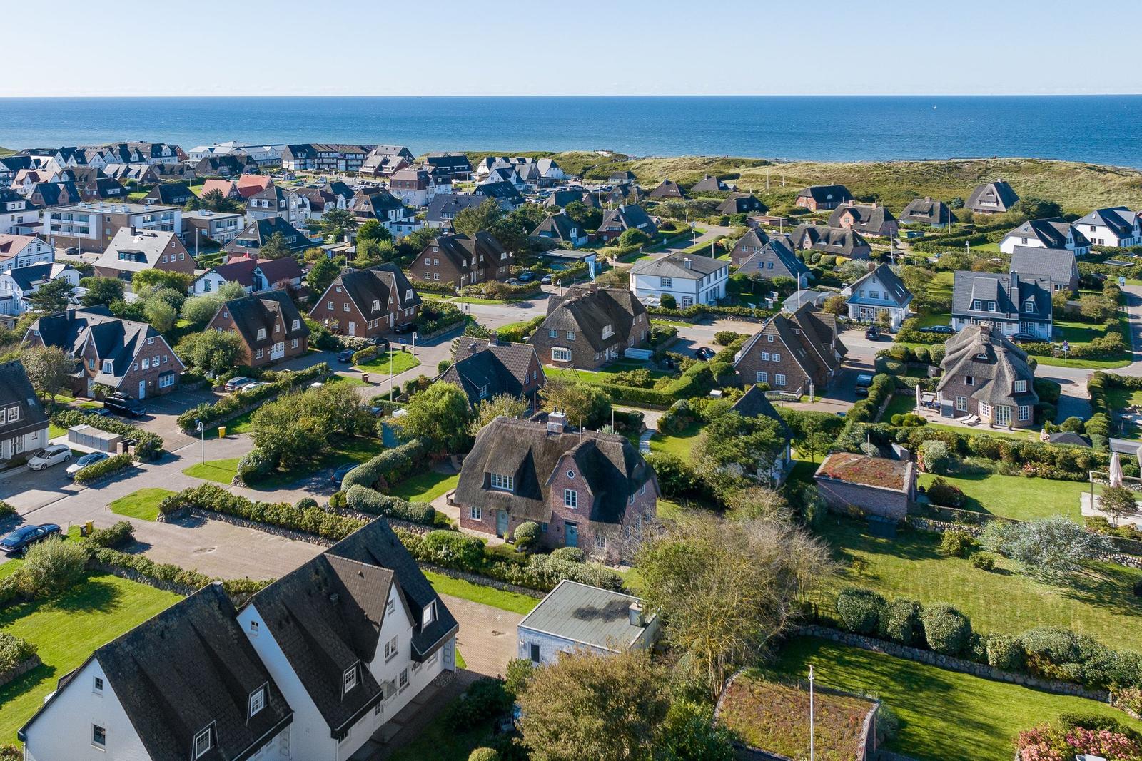 Dorf mit Häusern und Meer im Hintergrund